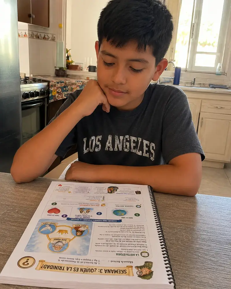 Niño escribiendo en el cuaderno Generación de Fe